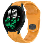 Football texture silicone watch band in orange for Samsung Galaxy Watch 4, showcasing its unique design and digital display.
